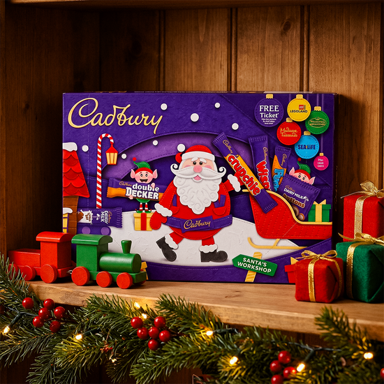 Cadbury advent calendar on a wooden mantelpiece with garland, gifts, and a toy train