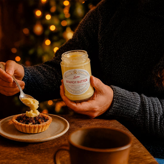Hands spreading honey from a jar onto toast
