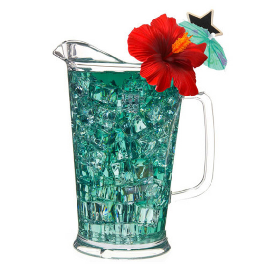 Clear pitcher filled with blue colored iced tea with ice and a red flower on a white background