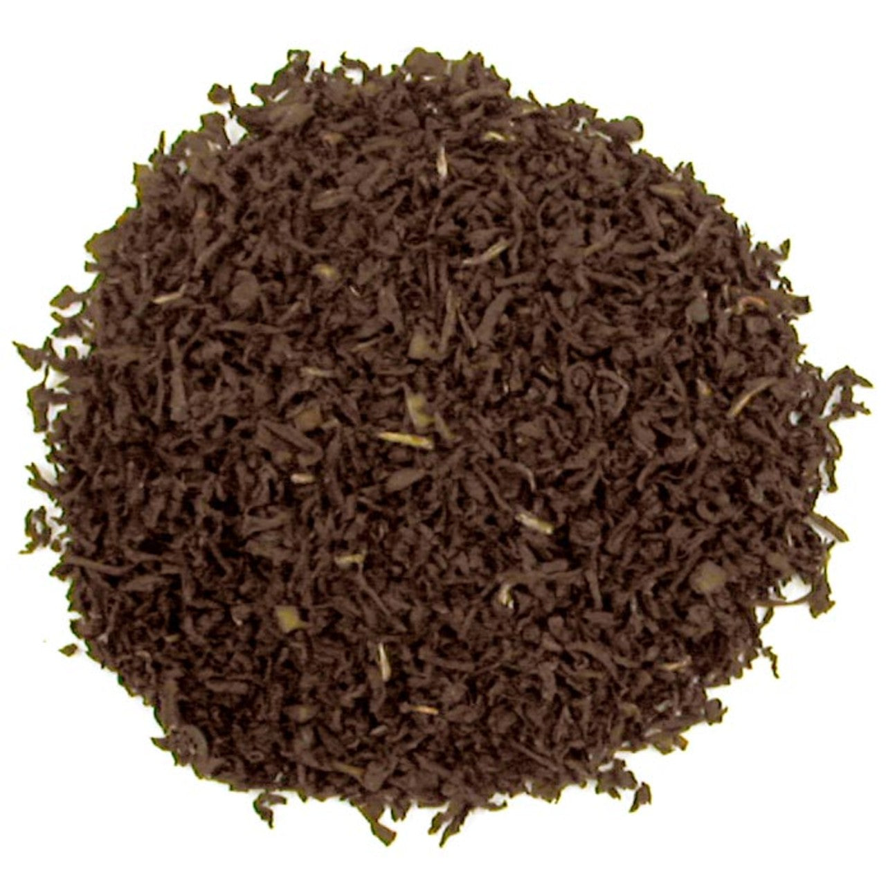 Close-up of dark brown tea leaves on a white background
