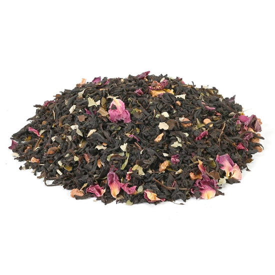 Black tea leaves with pink flowers on a white background