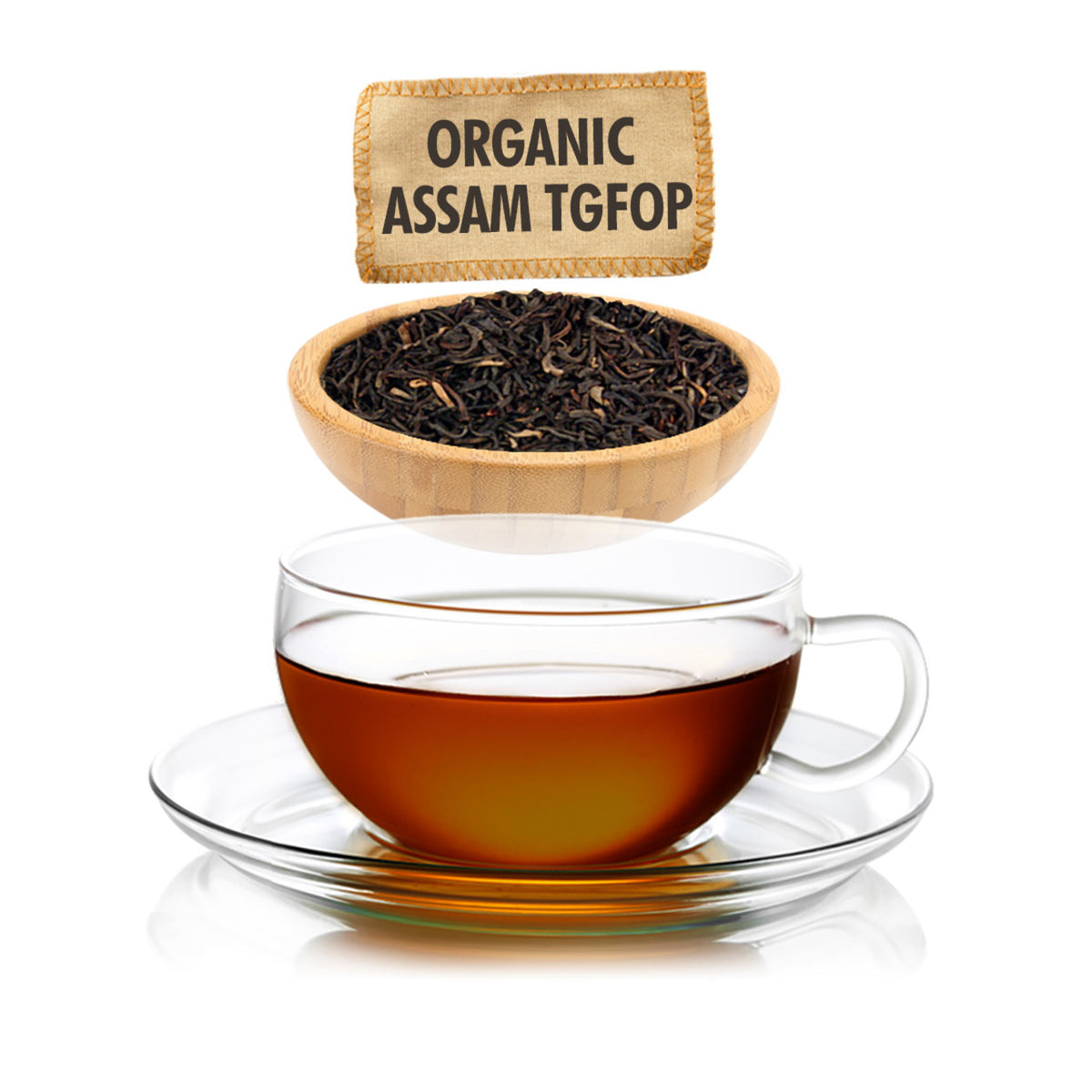 Clear glass teacup filled with dark amber tea on a white background with a wooden bowl of dry black tea leaves and a tag for with text for "Organic Assam TGFOP"