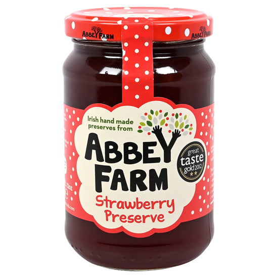 Jar of Abbey Farm Strawberry Preserve with a red lid on a white background