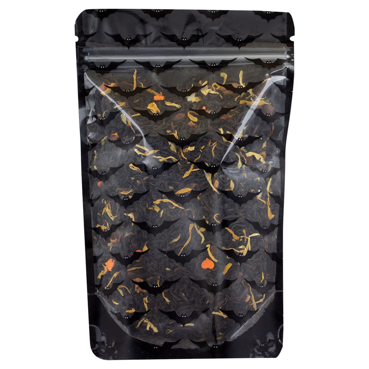A mix of dried black tea leaves and pieces of fruit and herbs, including apple, orange, and hibiscus, indicative of a spicy flavored tea in a sealed pouch with transparent front and black bat designs and a black backing on a white background.