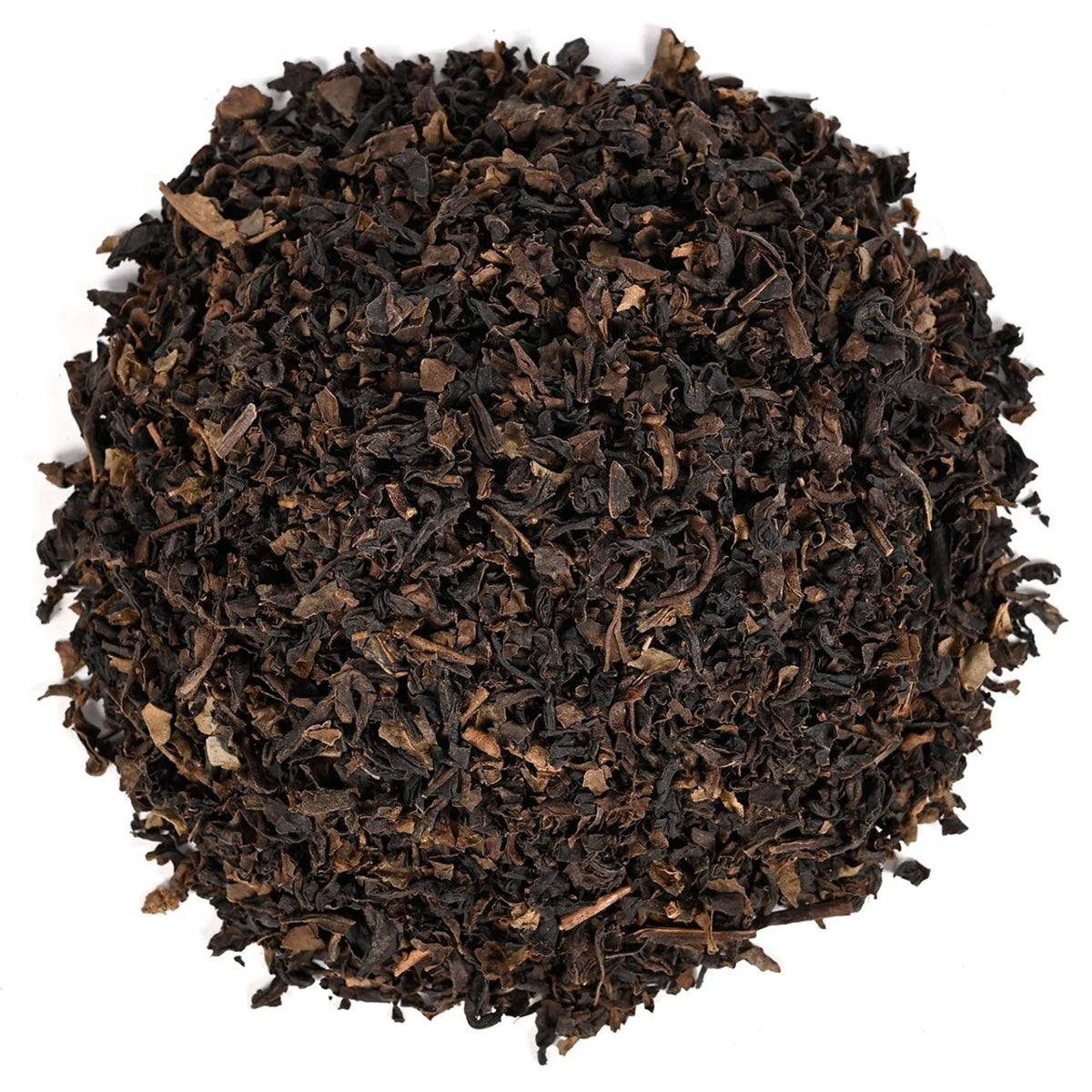 Close up of dry black tea leaves in a circular pattern on a white background.