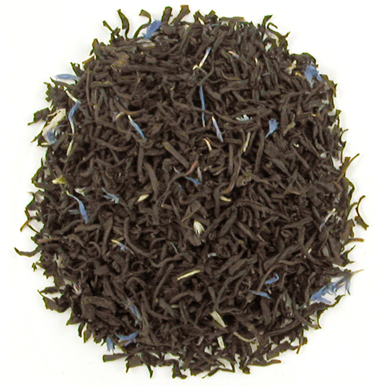 Close-up of dark brown tea leaves on a white background
