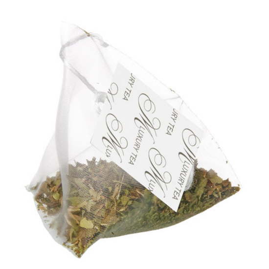 Tea bag with tea leaves in the bag and a visible label on a white background
