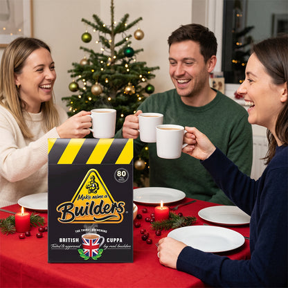Builder's tea box on a festive table with people raising mugs, a Christmas tree behind