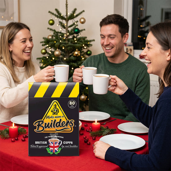Builder's tea box on a festive table with people raising mugs, a Christmas tree behind