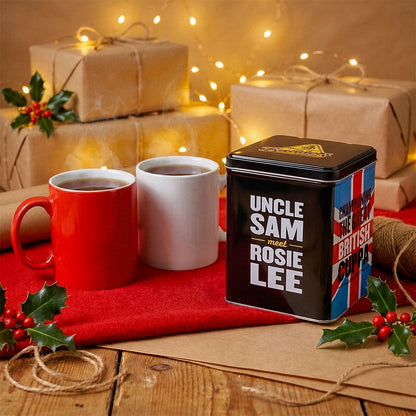 Uncle Sam Rosie Lee tea tin with mugs and wrapped gifts on a red cloth with festive lights