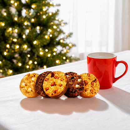 Cookies on a plate with a red mug in front of a Christmas tree