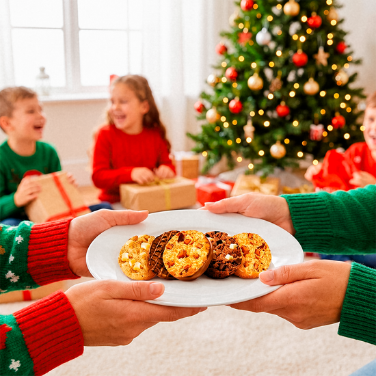 Family holding a plate of cookies near a Christmas tree
