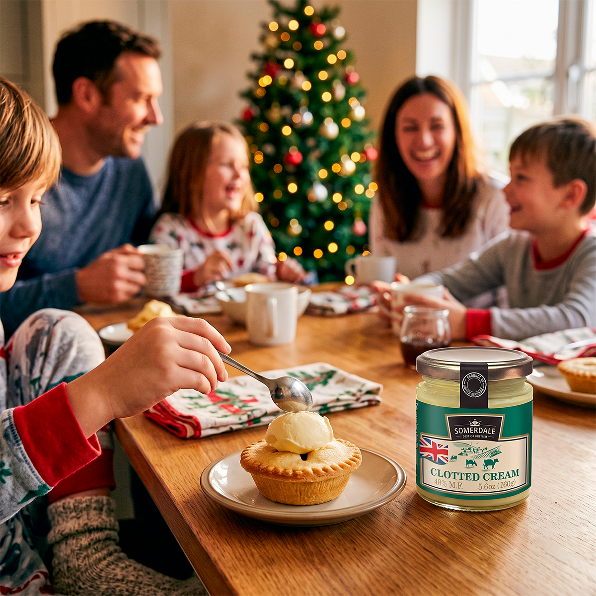 Family at a table with a jar of clotted cream, a mince pie, and a Christmas tree in the background