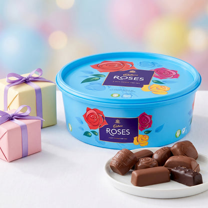 Blue Roses tub with a plate of chocolates, a wrapped gift, and festive lights.