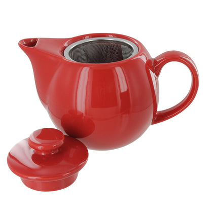 Red ceramic teapot with a lid on the side and a visible metal infuser inside the teapot all on a white background