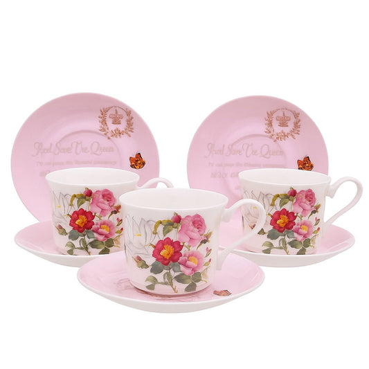 Set of ceramic cups and saucers with floral design on pink plates, featuring 'Goodwill Queen' branding.