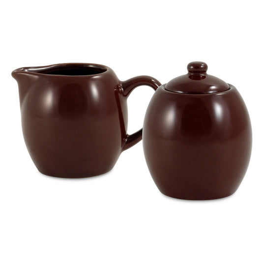 Brown ceramic creamer and sugar bowl set on a white background