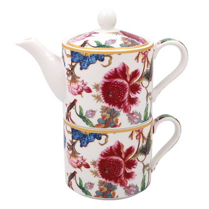 Decorative tea set for one featuring a teapot with floral and bird patterns stacked on a matching teacup on a white background