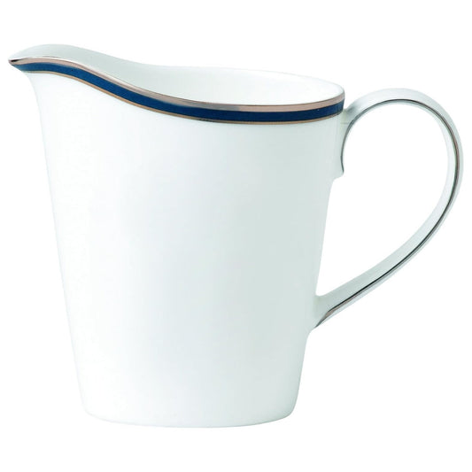 White creamer with blue rim and handle on a white background