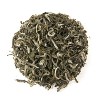 A close-up image of loose leaf green tea with visible white down on the leaves.