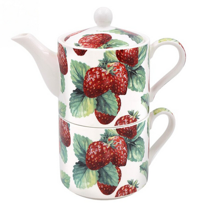 Tea for one tea set with a teapot stacked on a matching teacup both with strawberries and green leaves.