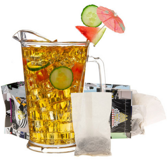 Glass pitcher filled with iced tea, garnished with cucumbers and watermelon, with tea bags and packaging in the background.