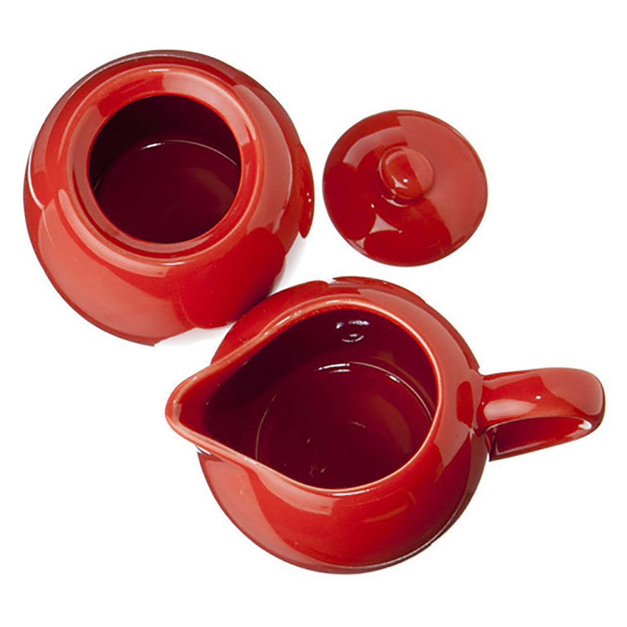 Red ceramic sugar and creamer set with sugar bowl lid on the side all on a white background