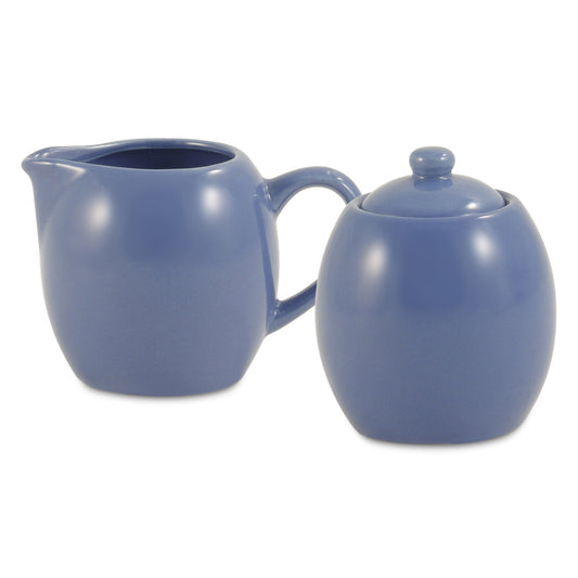 Blue ceramic creamer and sugar bowl set on a white background