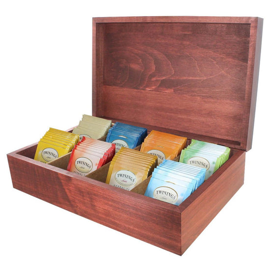Wooden tea box with assorted Twinings tea bags on a white background