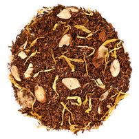 Brown Rooibos tea leaves with almond pieces and calendula petals in a circle on a white background.