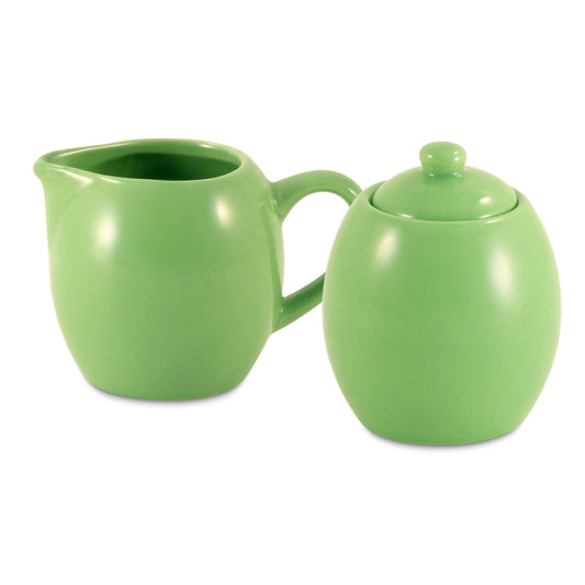 Green ceramic creamer and sugar bowl set on a white background