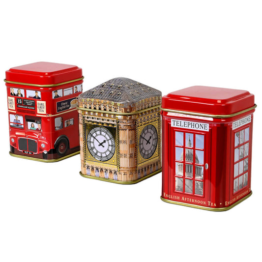 Three tea tins with London-themed designs featuring double decker bus, Big Ben, and a red phone booth all on a white background