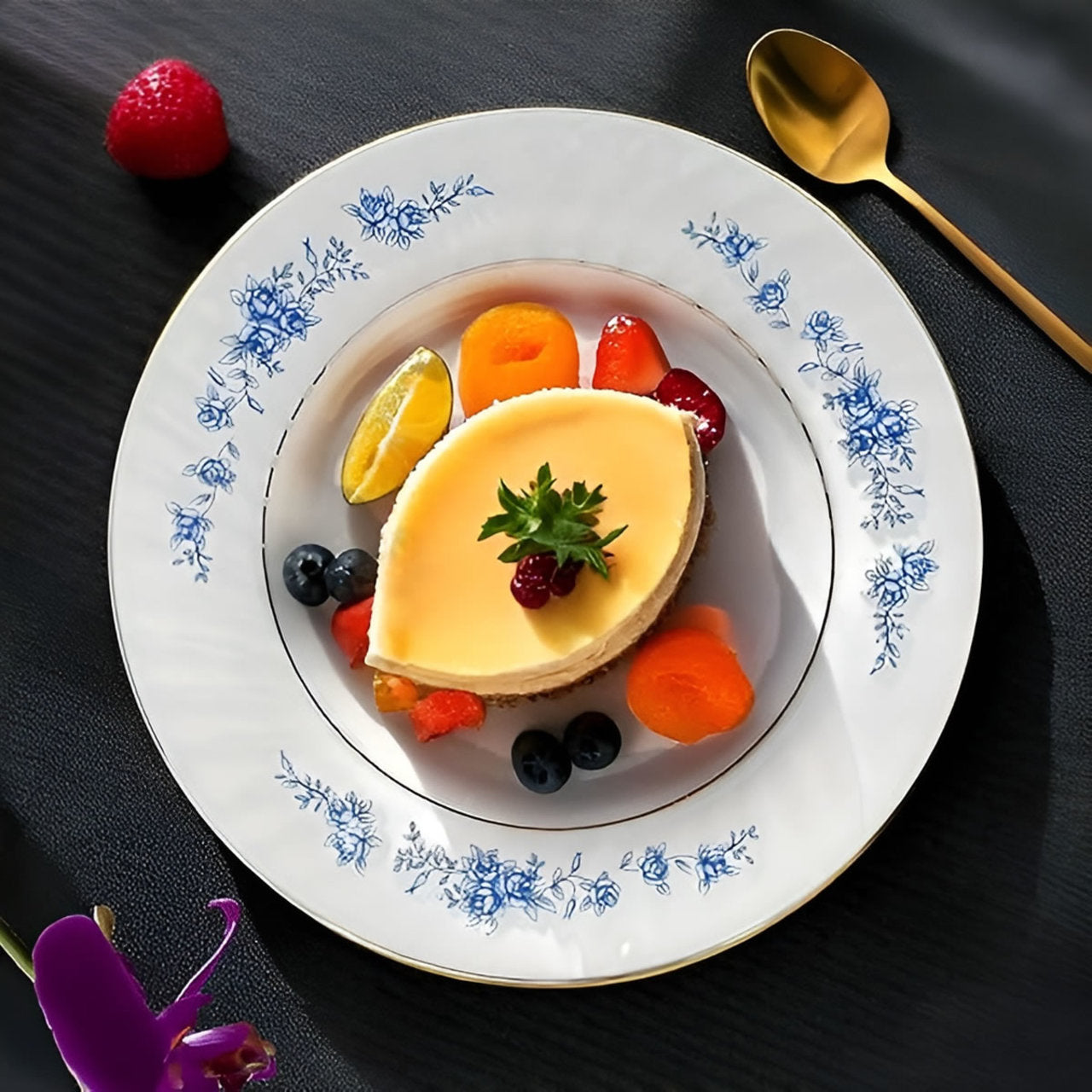 Delicate dessert with fruit on a decorative plate with floral patterns, set against a dark background.