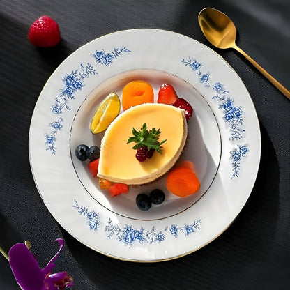 Delicate dessert with fruit on a decorative plate with floral patterns, set against a dark background.